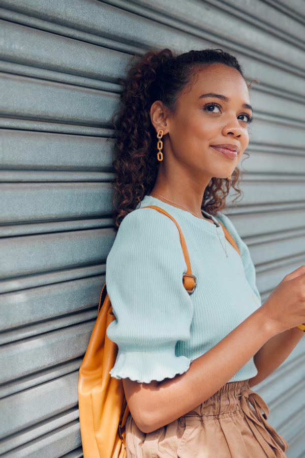 City lifestyle, girl with phone and bike standing at wall thinking before writing text. Happy female student, bicycle and smartphone outside street, communication, 5g and sustainable urban transport.